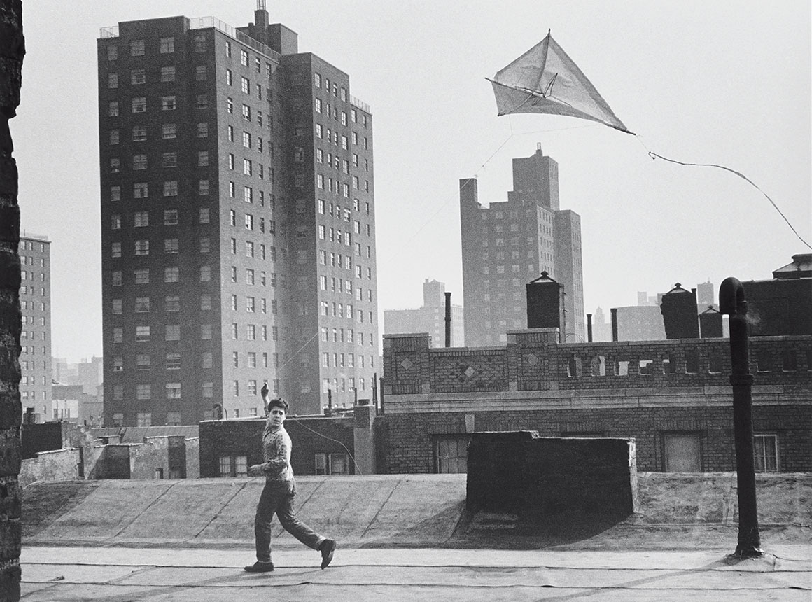 一个男孩在屋顶上放风筝的黑白照片