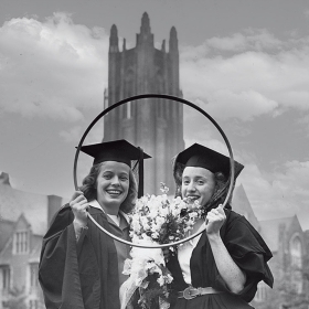 两名1945年的校友在赛后高举篮球的照片。获胜者将在她的砂浆板上系上新娘面纱。
