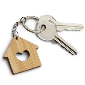 一张钥匙圈的照片，上面有一个木制的房子，房子的中心刻着一颗心，还有两把钥匙。