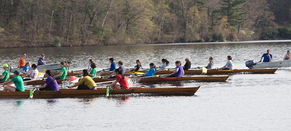 Dorms race past each other in a crew regatta on Lake Waban