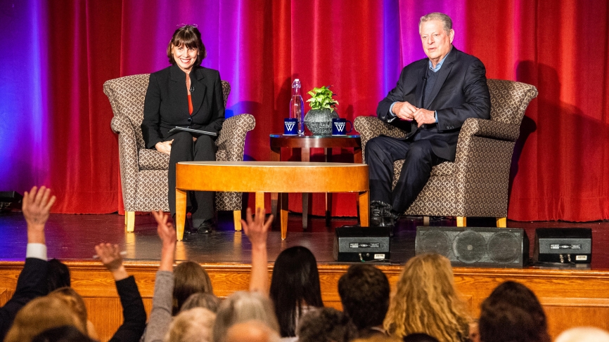 阿尔·戈尔和苏·瓦格纳坐在舞台上，面前坐满了观众。