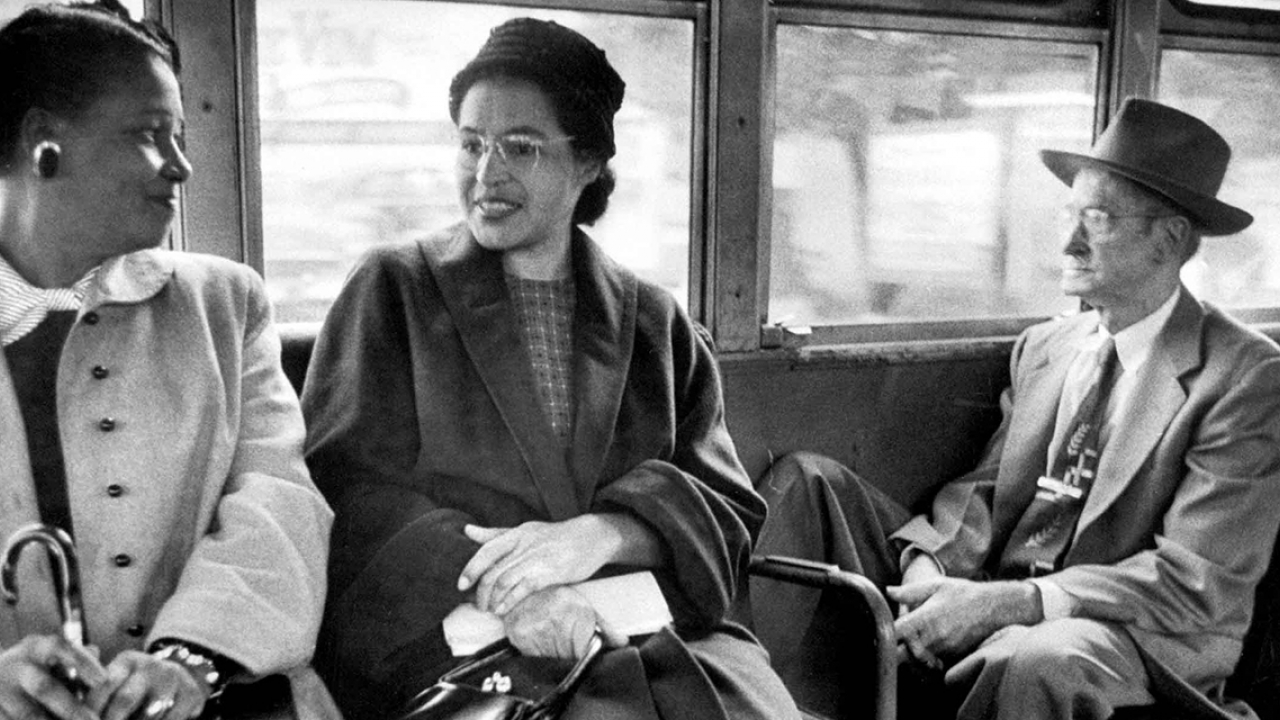 罗莎·帕克斯(中)坐在公交车上与另一位女士交谈。