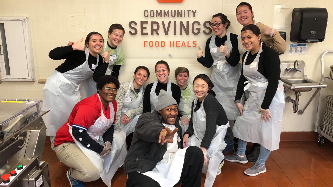 社区服务的学生的小组照片，这是一家波士顿非营利组织，可烹饪和提供食物。