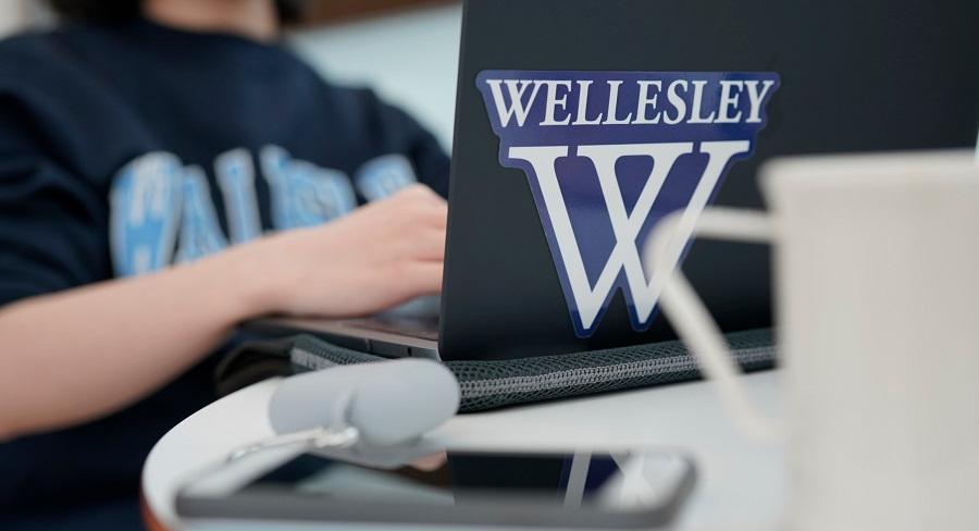 一台笔记本电脑的学生类型与Wellesley College Logo贴纸亚博电竞官网在前面