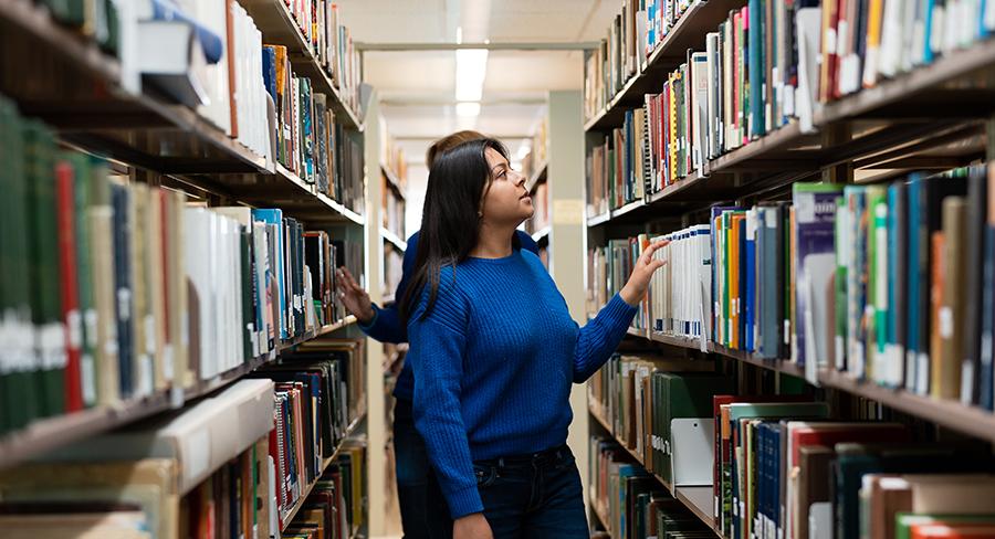 Two students browse for books in the Wellesley College Clapp Library