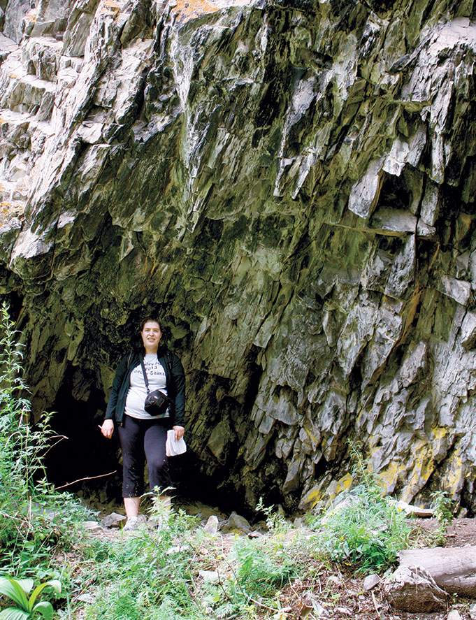 2009年，一名学生在Bol 'shaia Kadilnaia山谷上方的山洞入口处摆姿势。