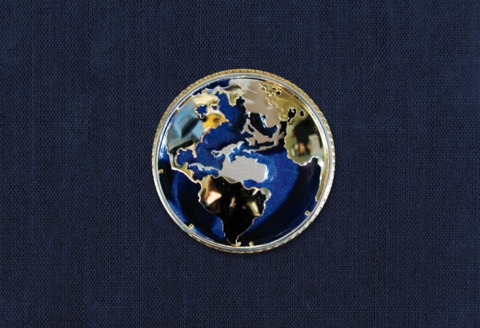 国务卿奥尔布赖特的胸针描绘了一个地球仪，蓝色背景上用金色和银色绘有大陆。
