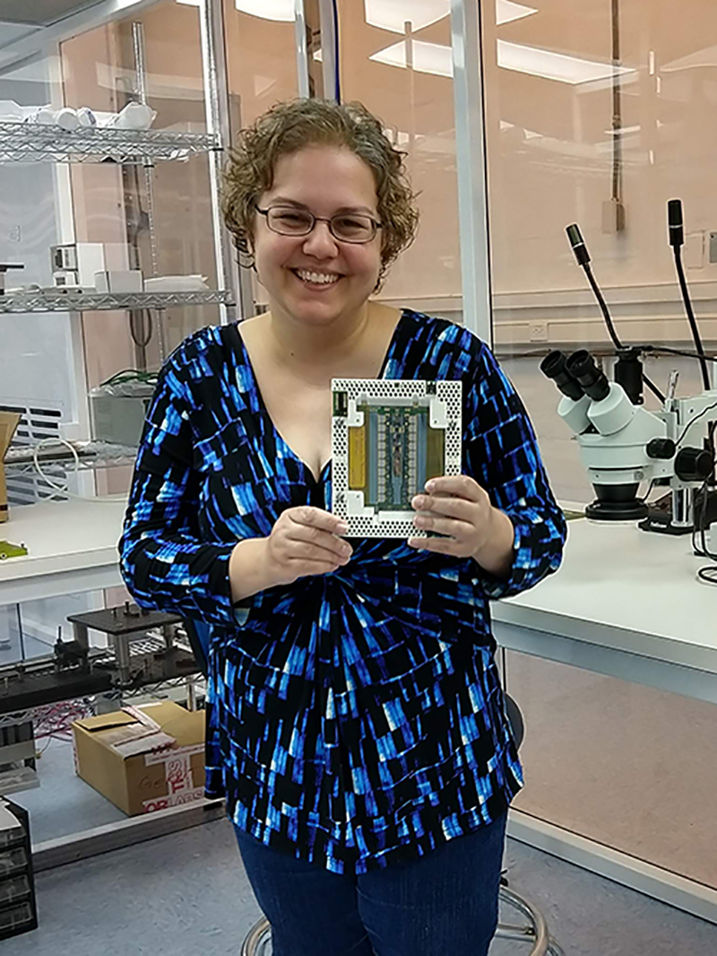 凯瑟琳·尼科洛夫在长岛布鲁克海文国家实验室的实验室里拿着一个硅探测器模块。