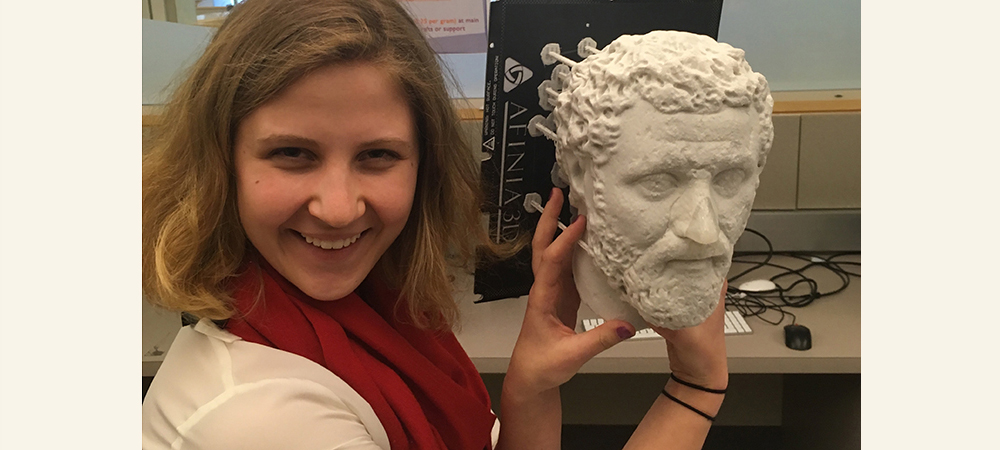 拿着希腊雕象的学生在她的头和微笑旁边