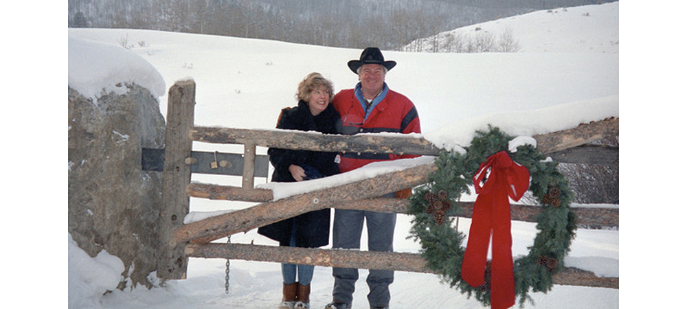 在多雪的景观和在与圣诞节花圈的门后面的Betsy和芽