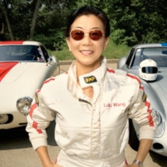露露·乔·王（Lulu Chow Wang）在她的两个赛车面前