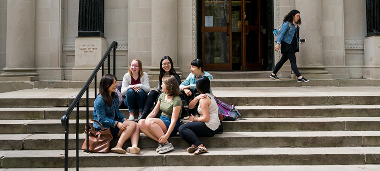 Wellesley students engage in lively discourse on the library steps.