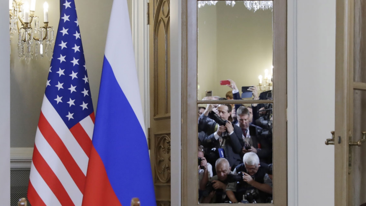 美国和俄罗斯国旗竖立在会议室外，国际媒体成员在这里拍照。