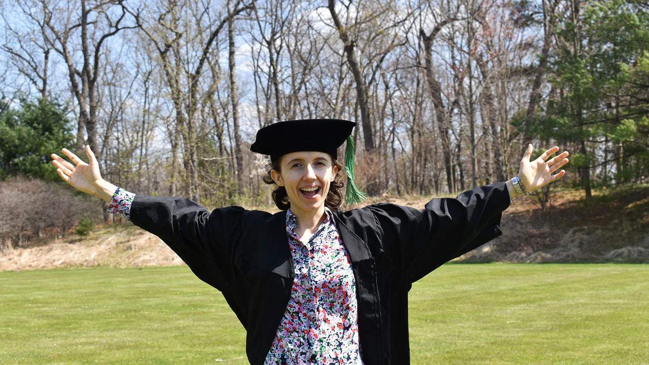 21年的Liz Borecki穿着毕业典礼长袍站在校园里