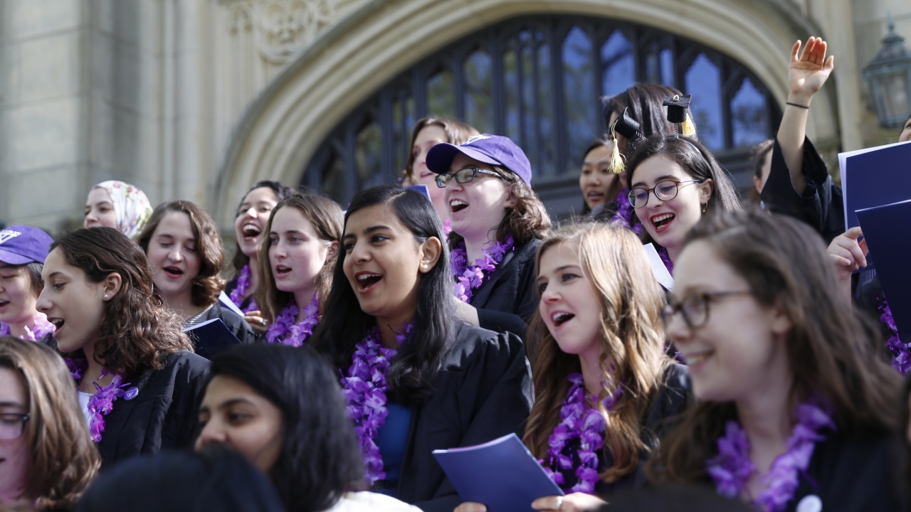 韦尔斯利学院2018届毕业生在霍顿教堂的台阶上唱歌。亚博电竞官网