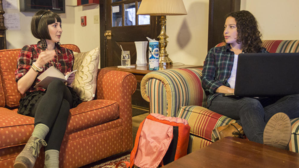 两个学生在宿舍的客厅里进行对话。